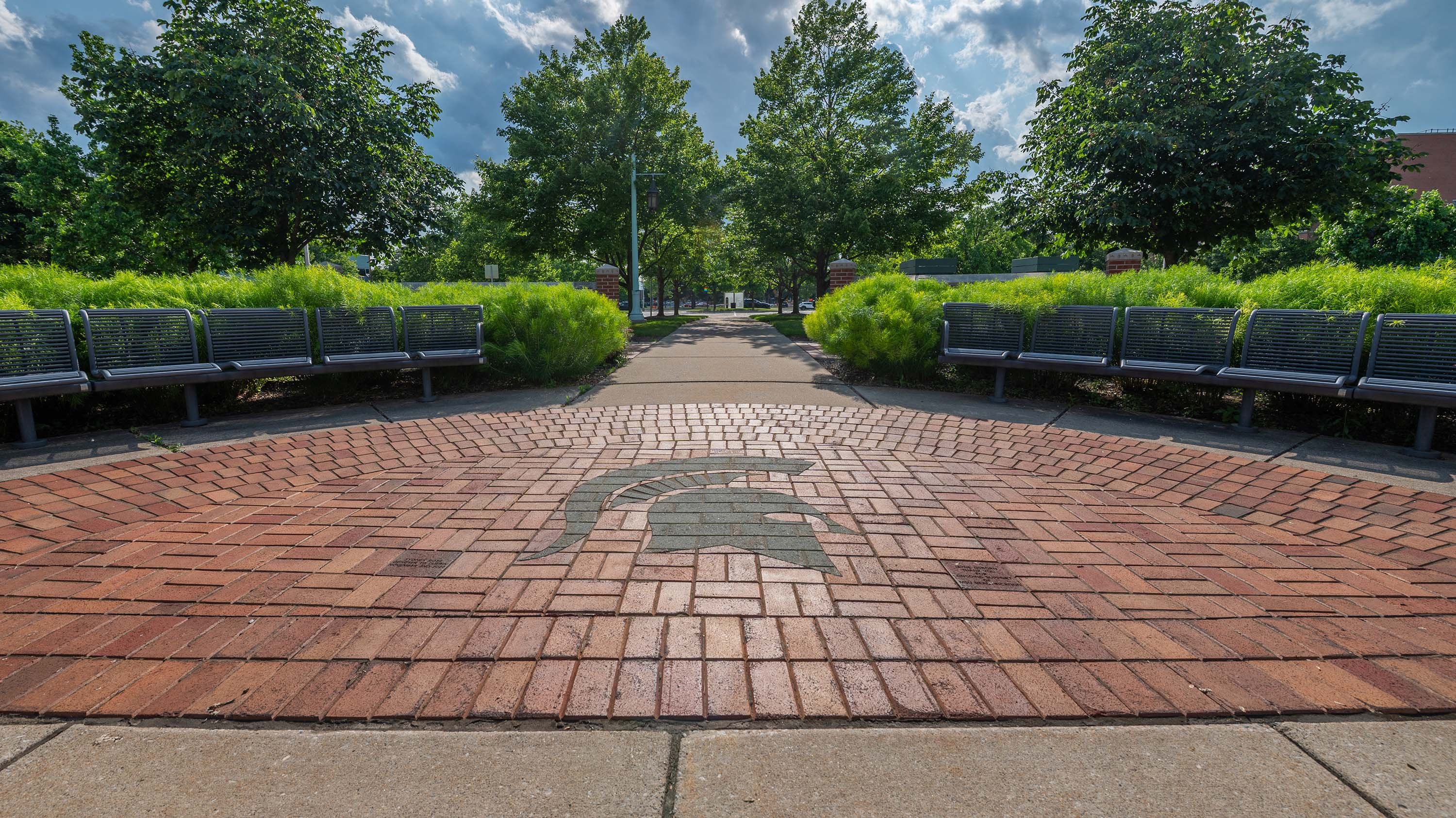 Bricks in a courtyard forming the shape of a Spartan helmet