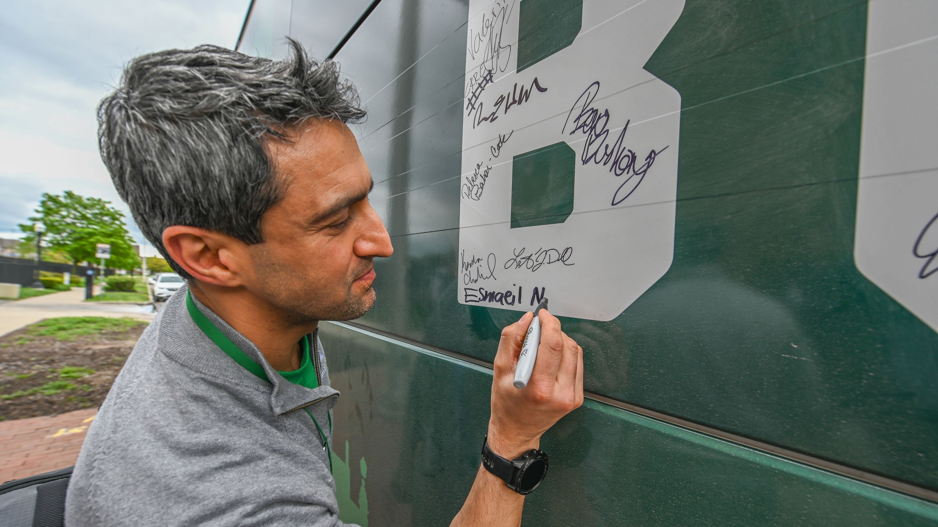 A man writes his signature inside a block letter ?B?
