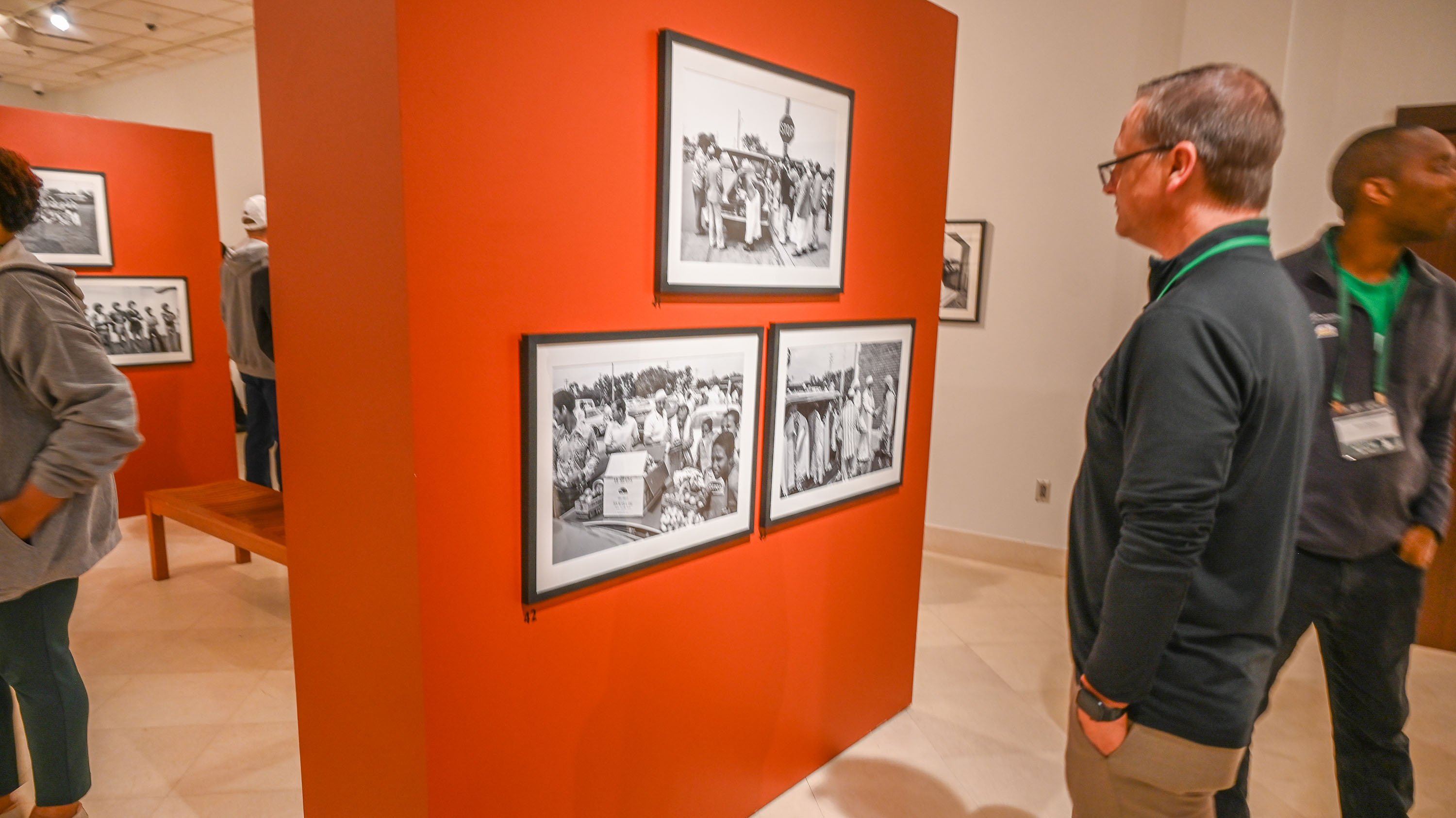 A man looking at photos on a wall