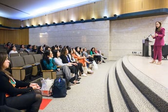 a speaker stands on stage addressing participants