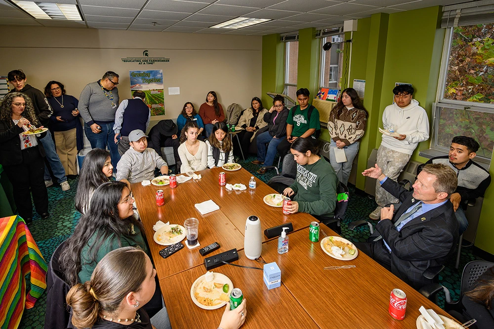 MSU president having a meal and discussing with students