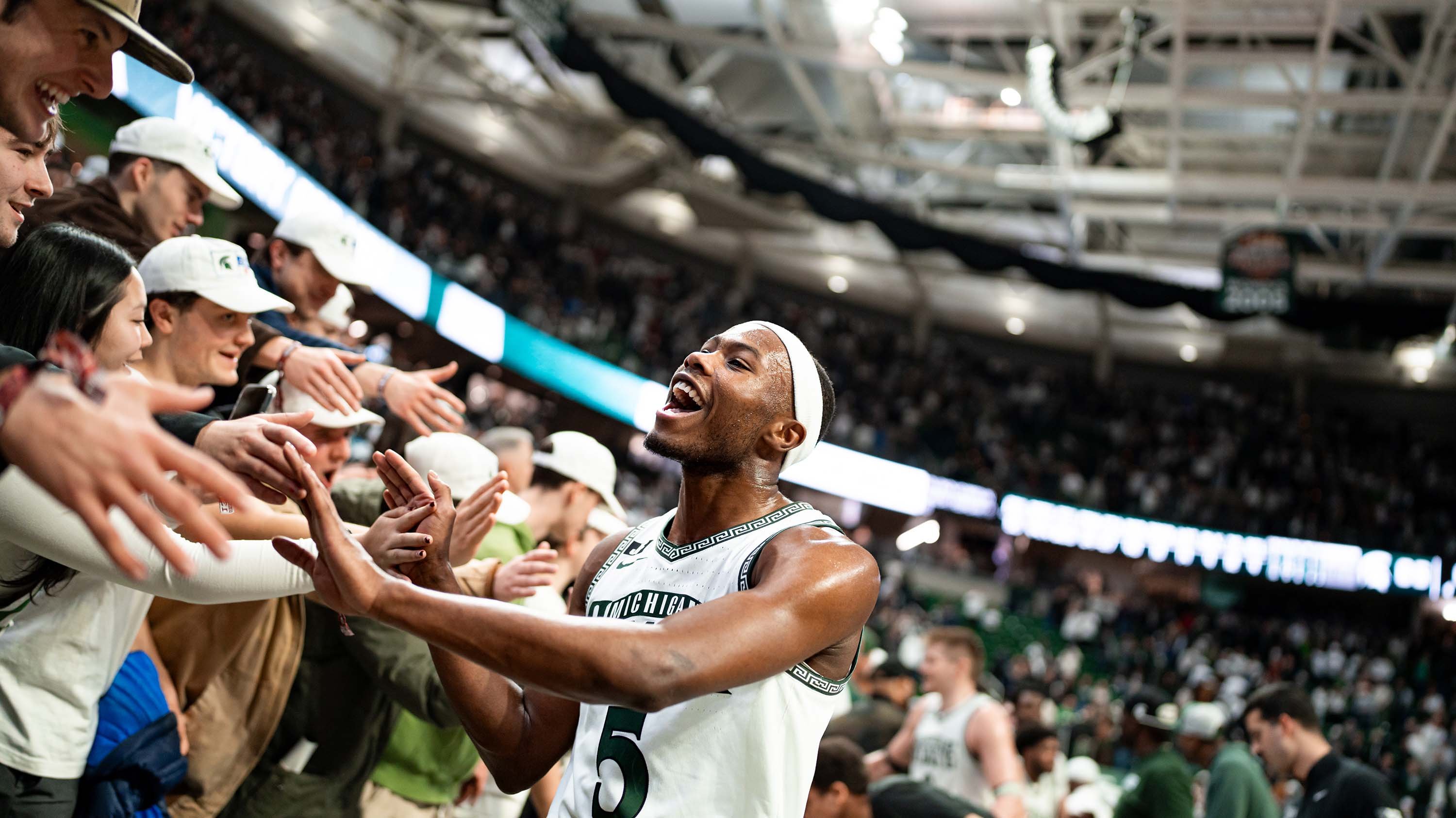 MSU junior and member of the men?s basketball team, Tre Holloman, high-fives members of the Izzone.