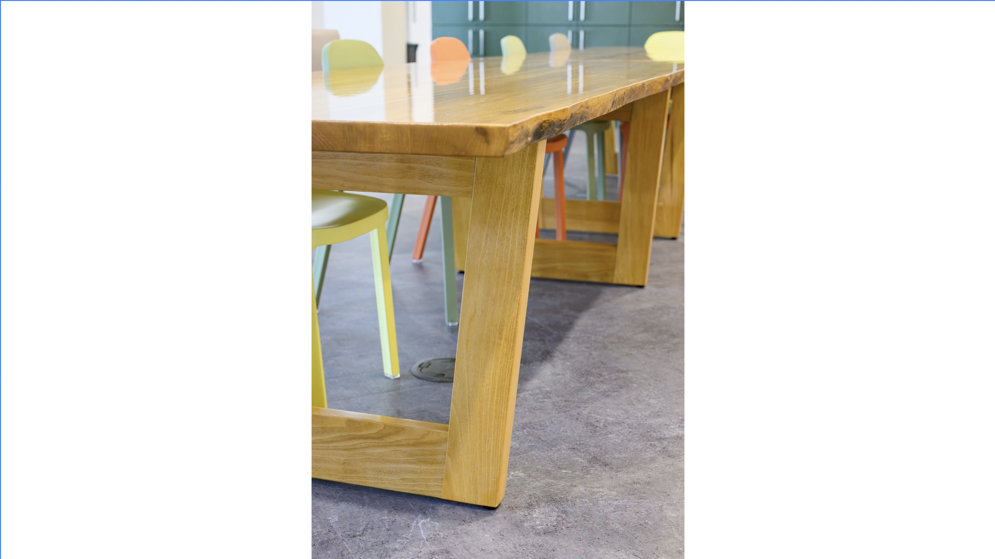 Close-up of a wooden table made from a fallen sycamore tree on MSU campus with colorful chairs at the MSU Multicultural Center