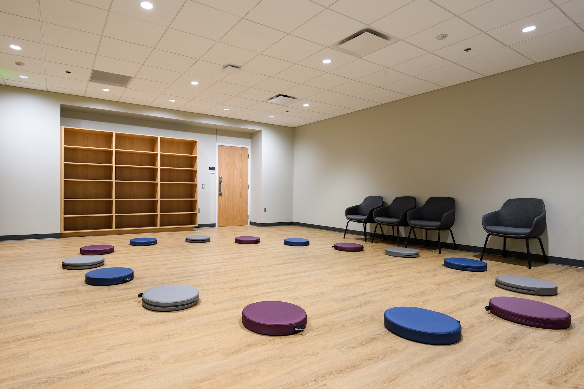 A circle of meditation cushions in a room with wood floors in the MSU Multicultural Center
