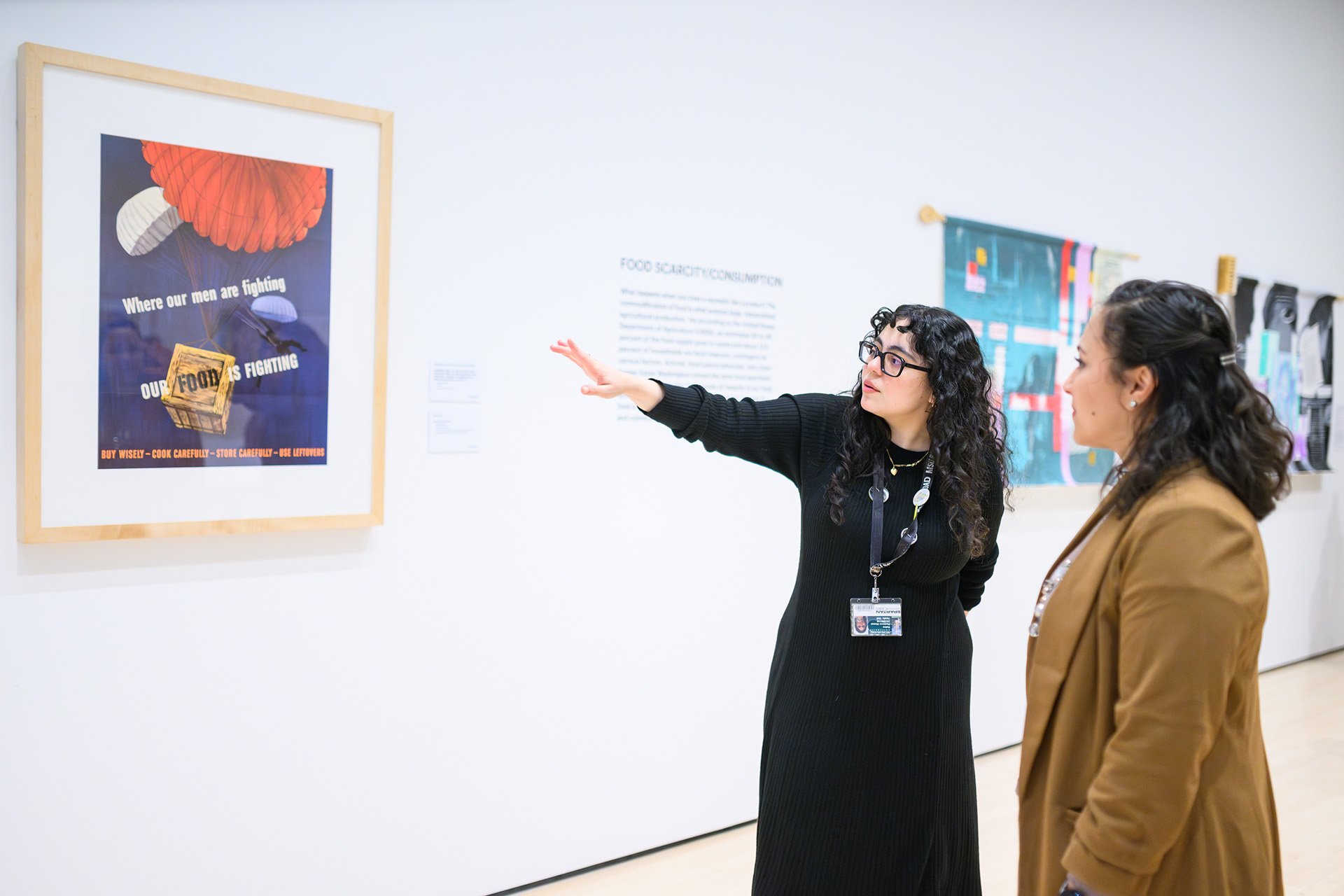 museum curator talks about a framed illustration with a visitor