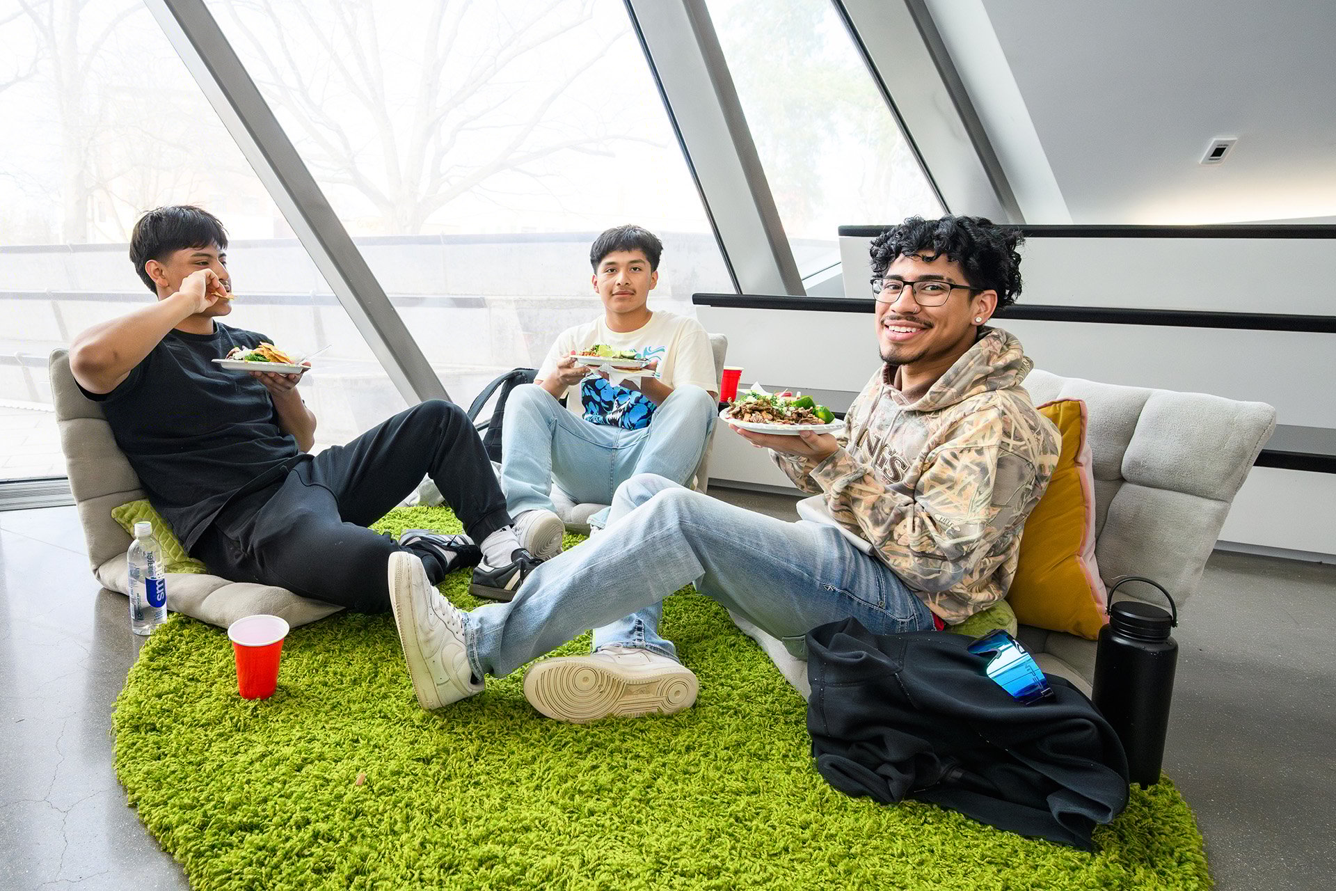 three visitors sit and enjoy food