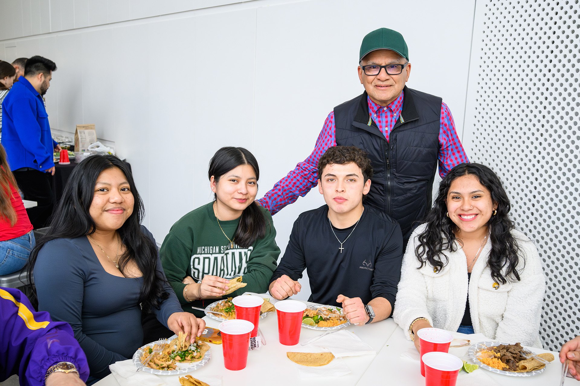 a group of five people are getting ready to eat at a table