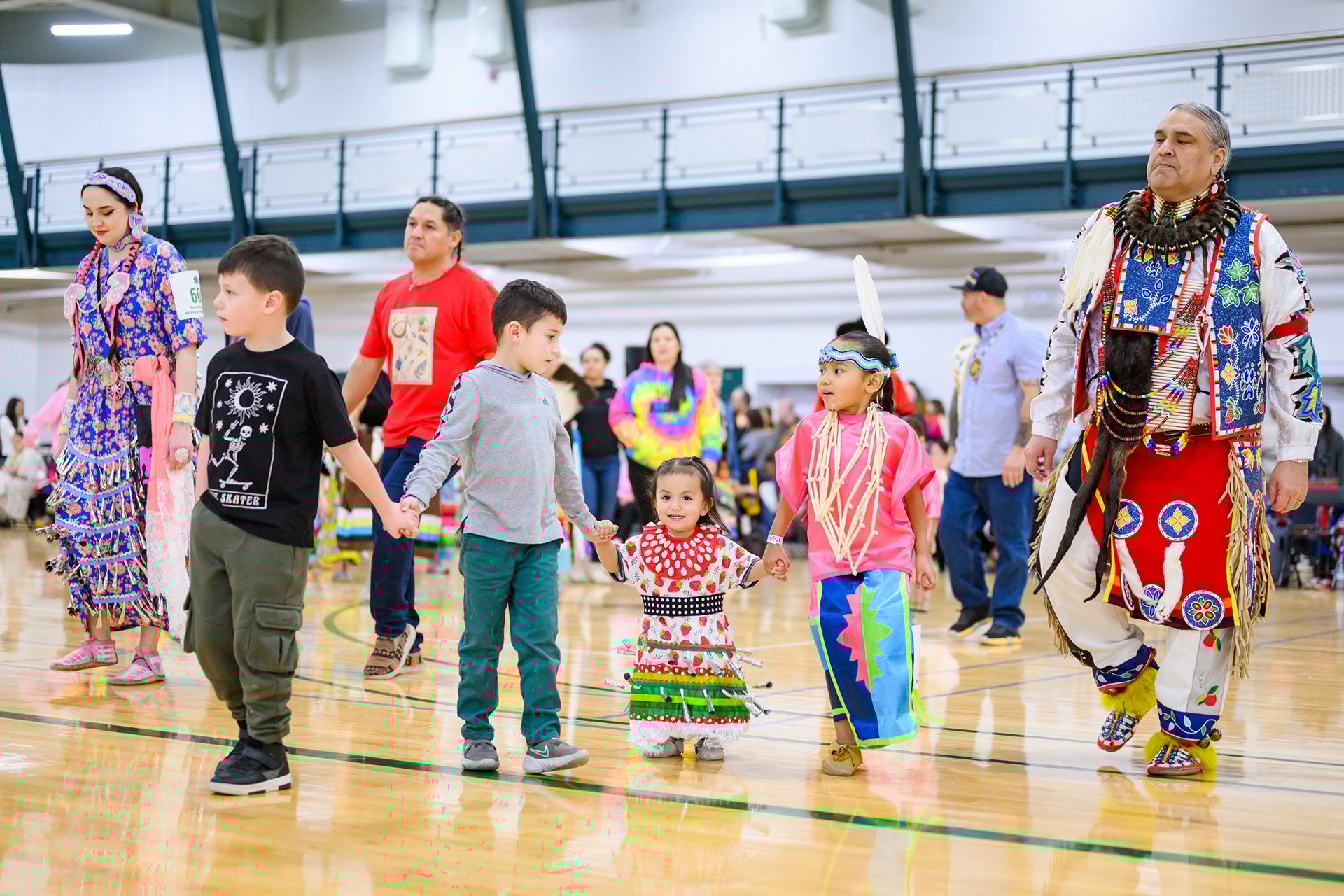 Generations of powwow dancers stand together