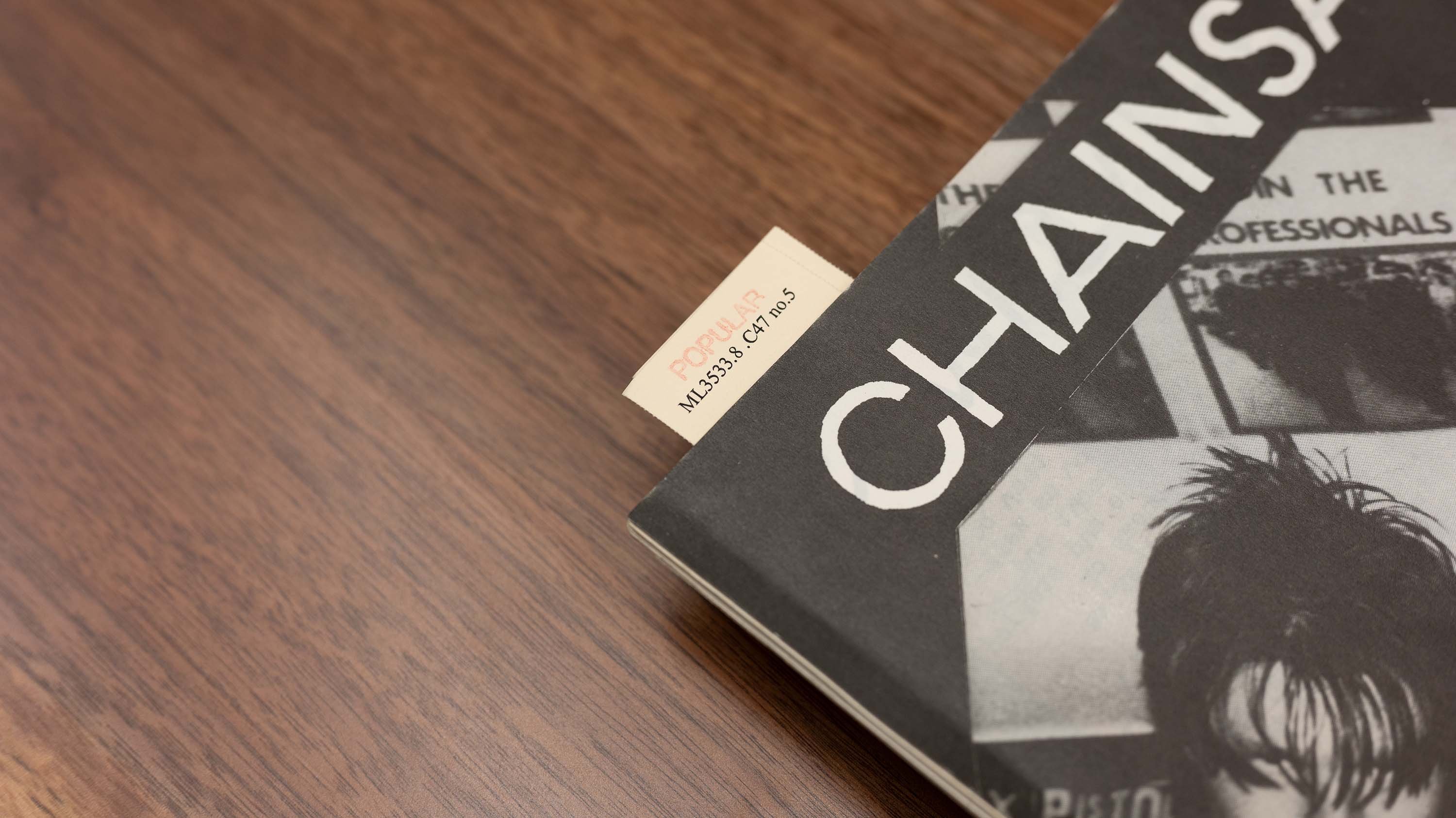 A book with a black cover and the word 'CHAINS' printed in white. Because the full magazine cannot be seen, the title of the magazine is actually CHAINSAW