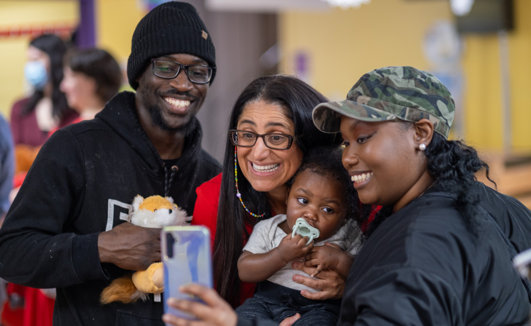 Mona Hanna, Associate Dean for Public Health, poses for a selfie with a family at  Rx Kids' celebration. 