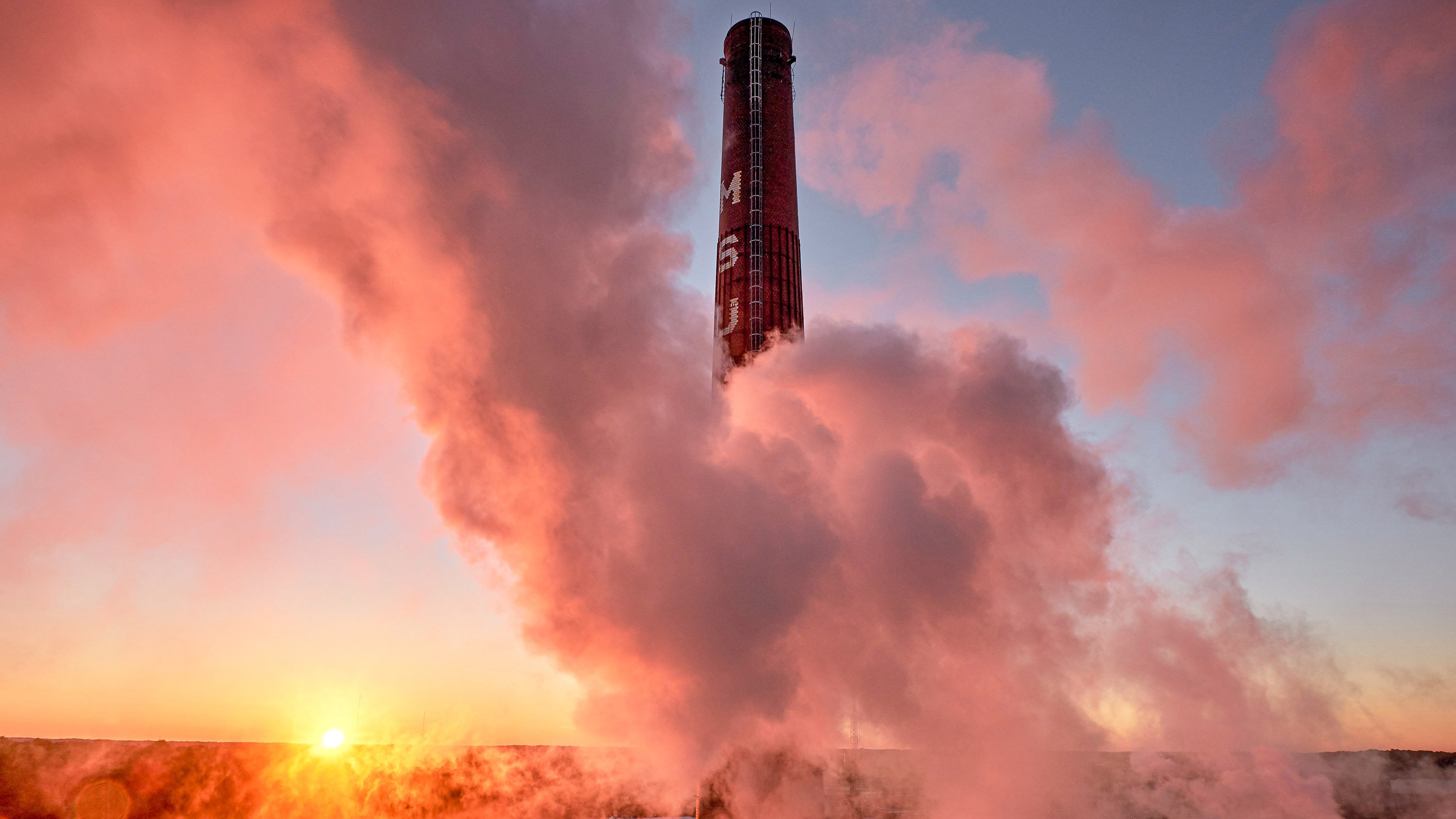 Power plant smokestacks behind clouds of steam