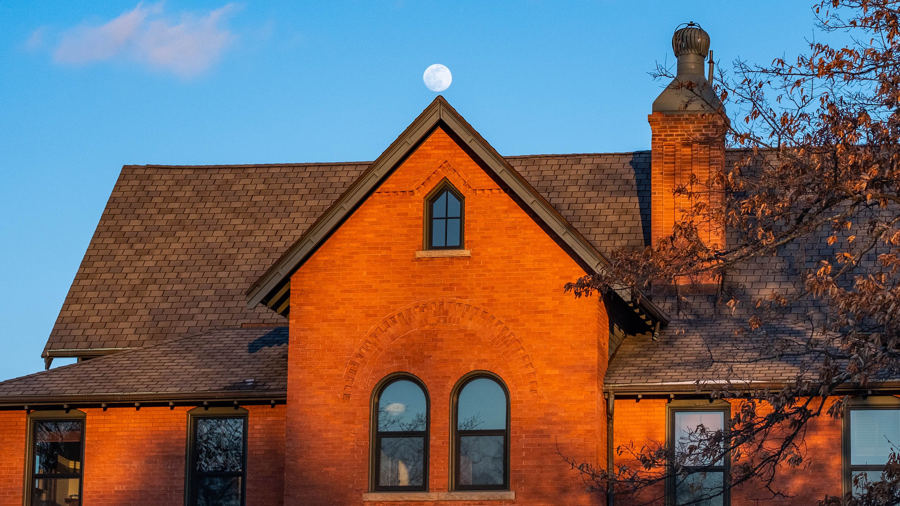 Cook Hall with a full moon in the sky