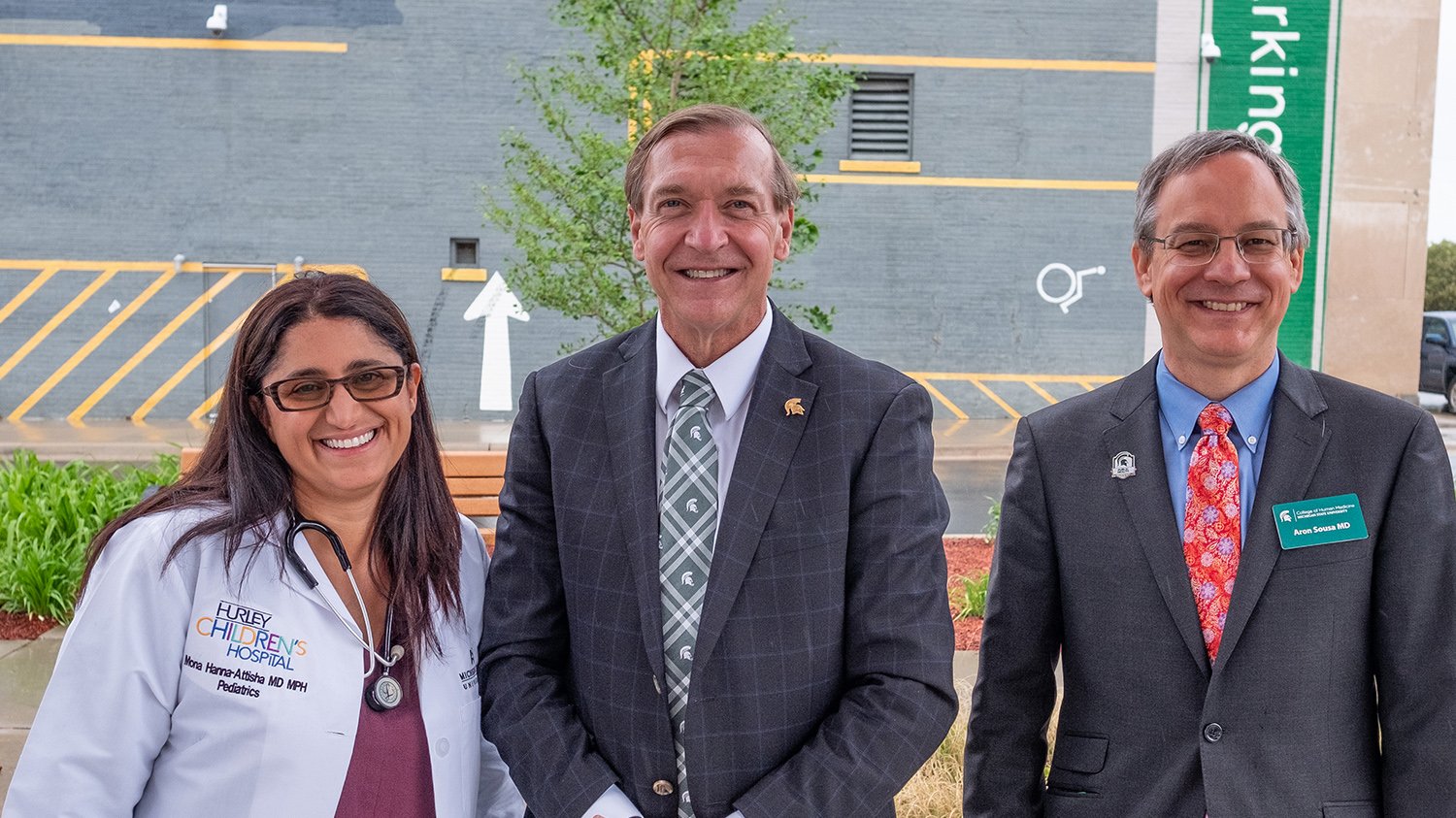 Mona Hanna-Attisha, President Stanley, and Aron Sousa standing outside of the College of Human Medicine Flint Campus