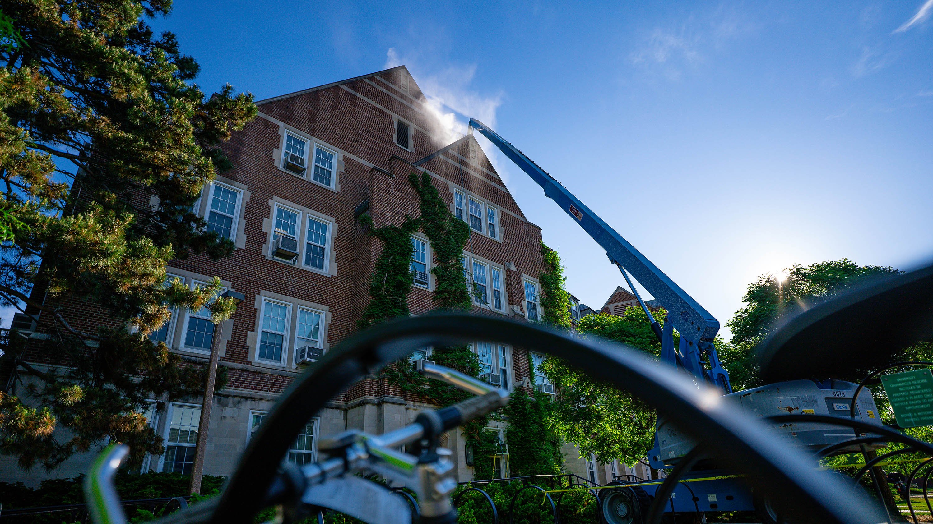 Natural Sciences building being pressure washed by crew in a cherry-picker