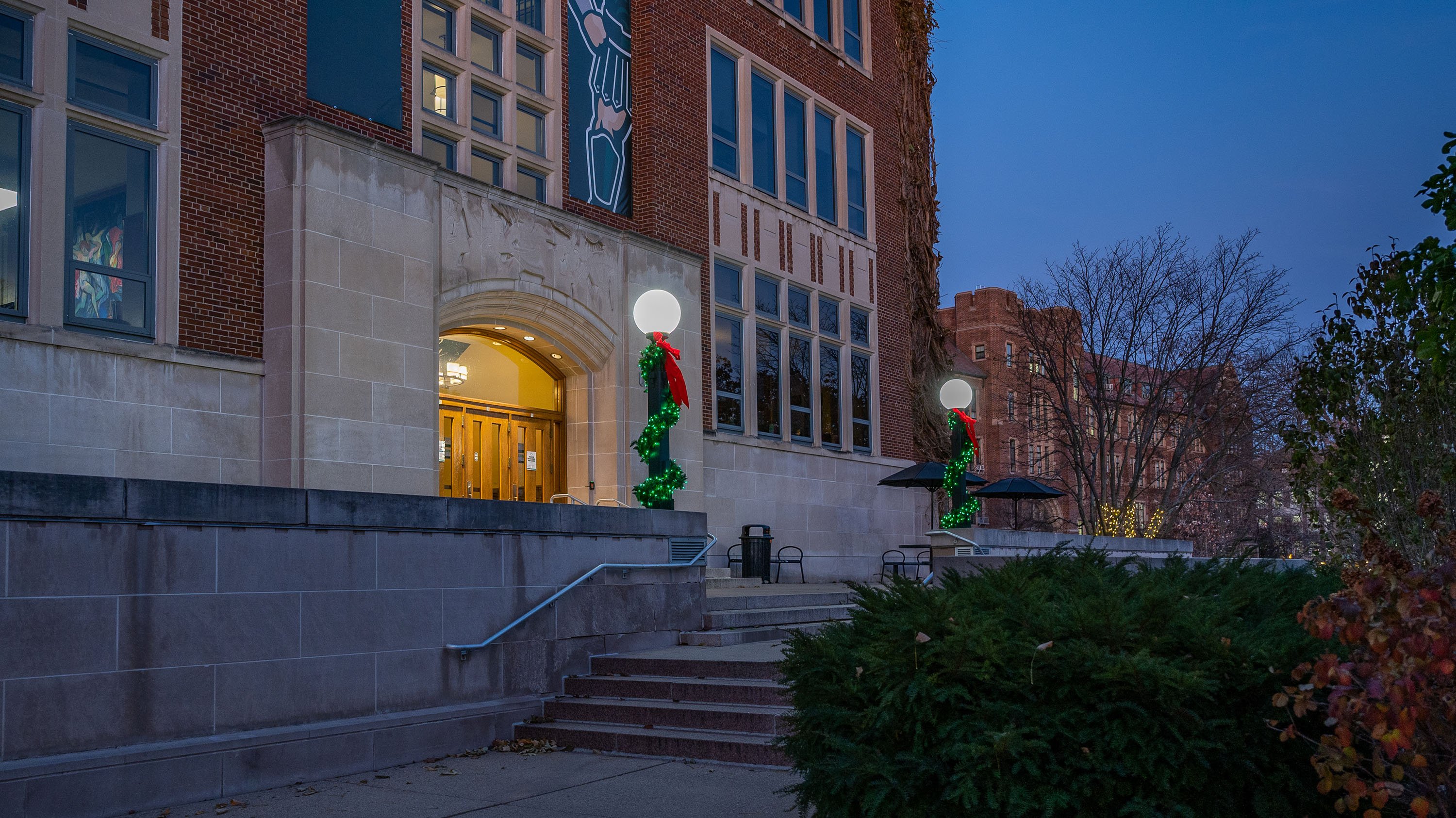 MSU Union with light posts decorated for the holidays with greenery, red ribbon and lights
