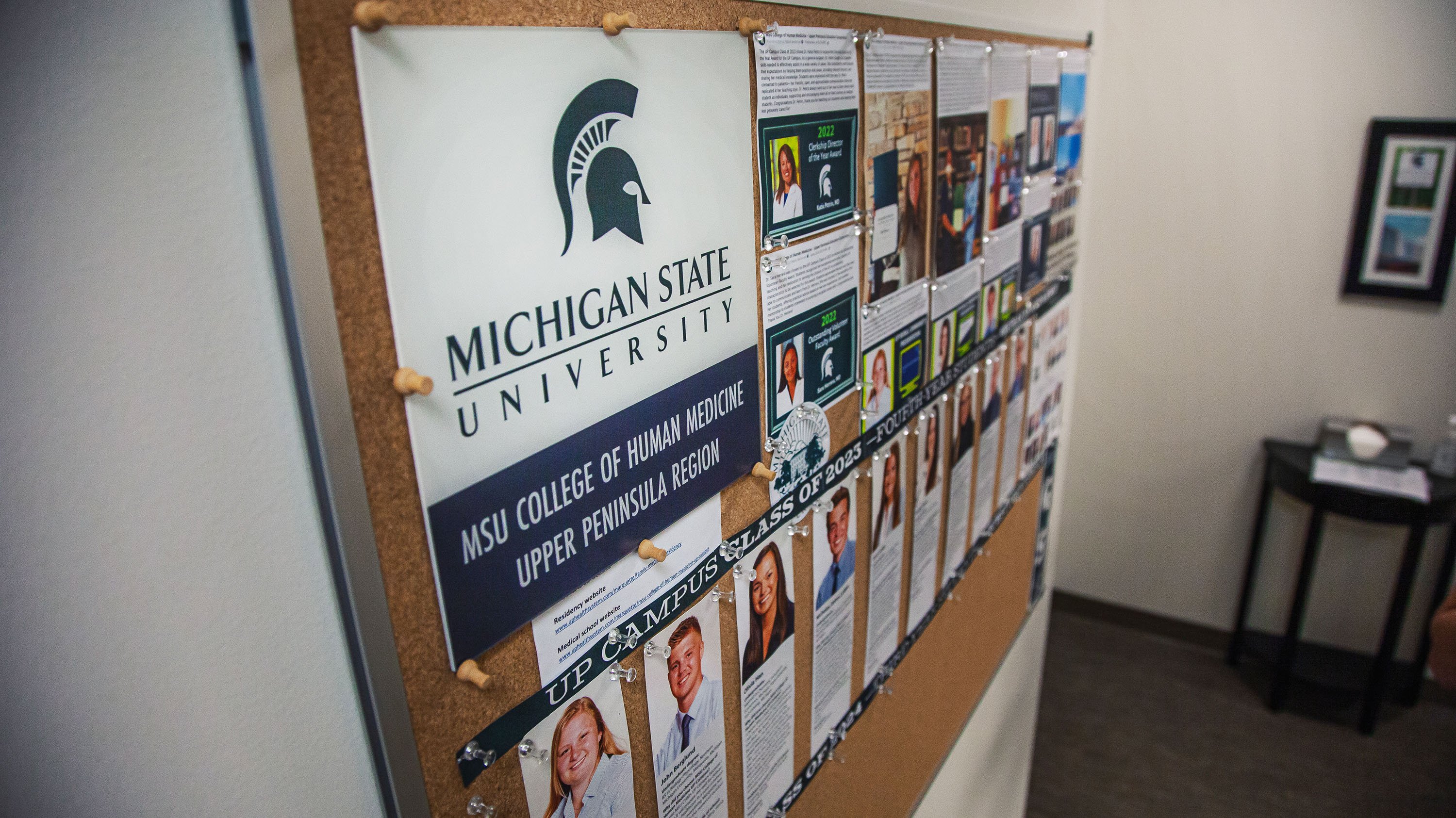 A poster features the MSU College of Human Medicine Upper Peninsula Region personnel and resources, including the U.P. campus residents and students. 