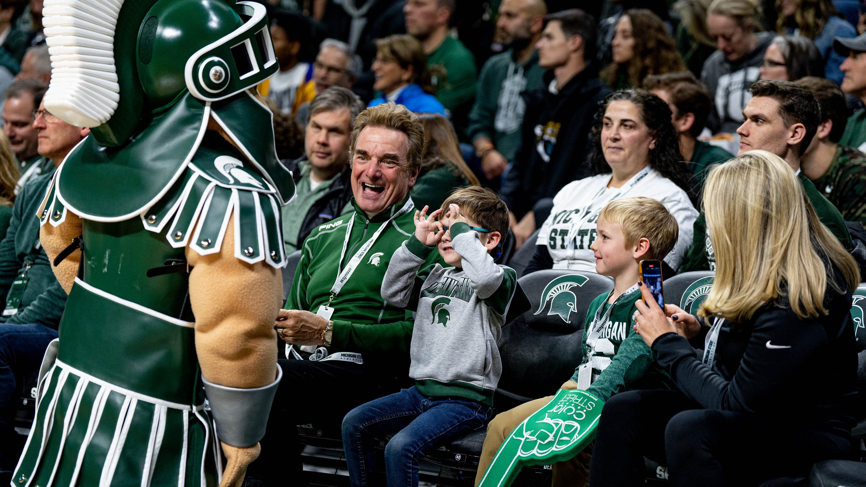 Sparty interacts with a young fan at an MSU basketball game