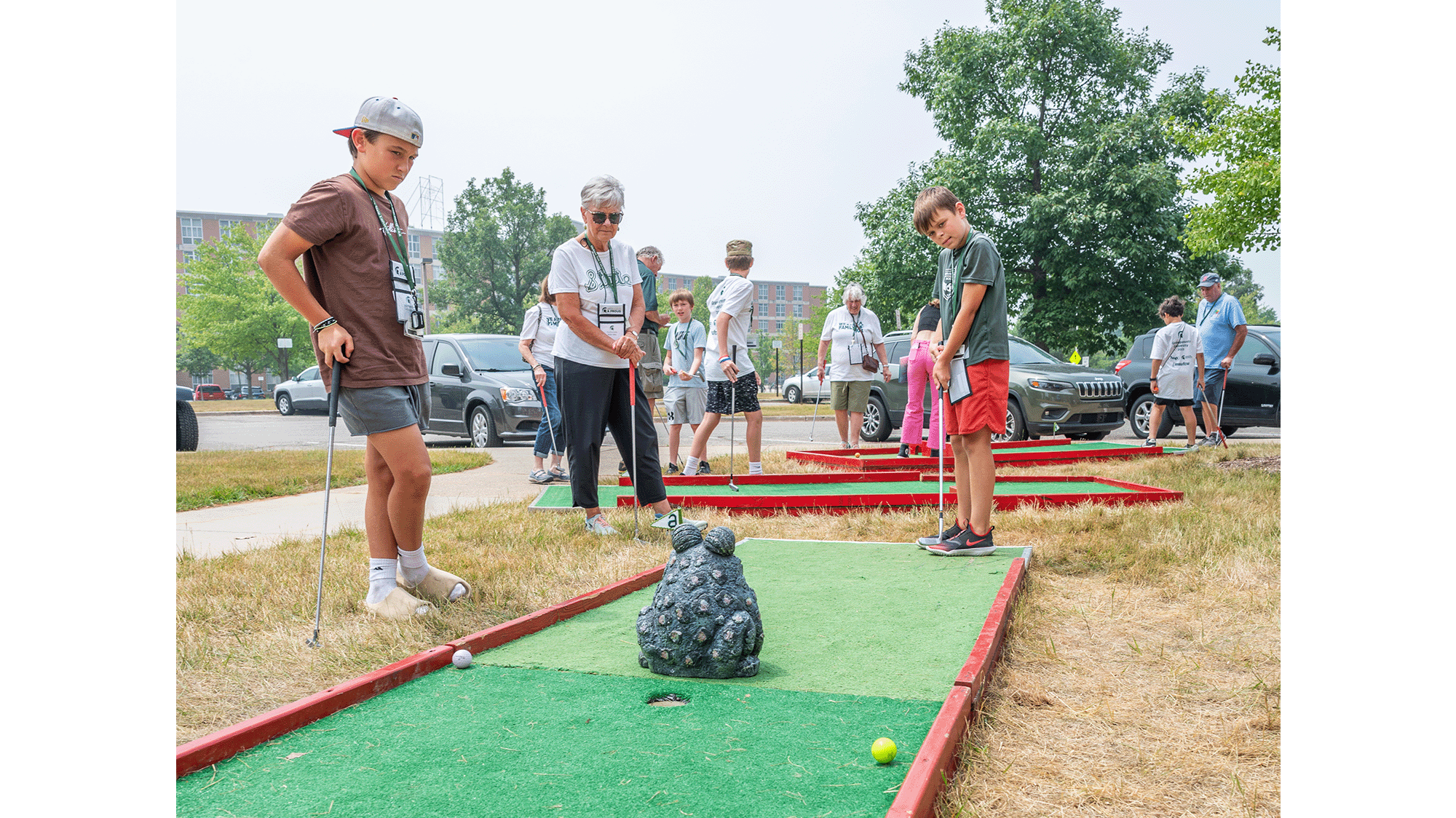 Grandparents and grandchildren playing mini-golf