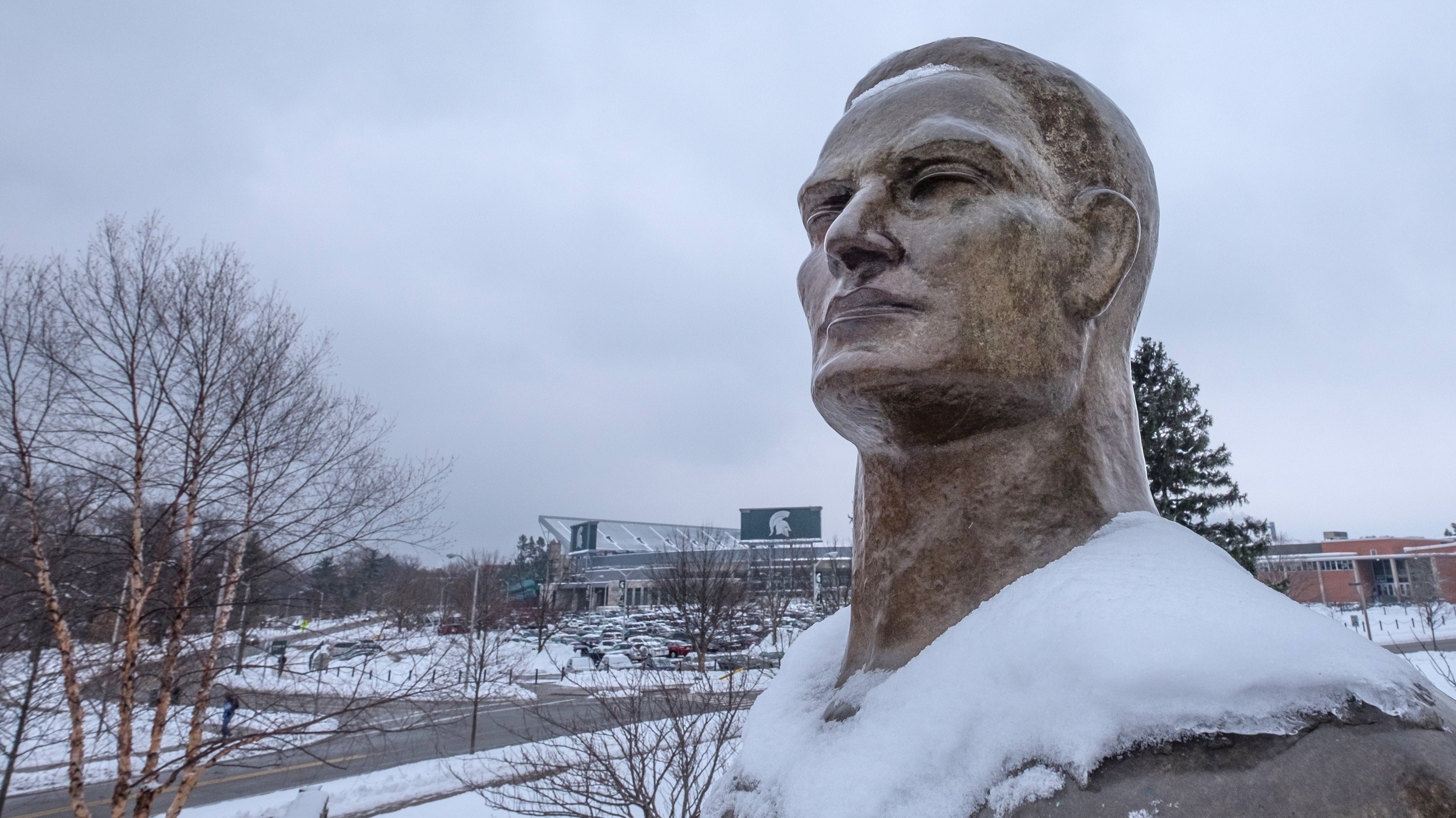 A close-up of the Spartan Statue that is dusted with snow on its shoulders. 