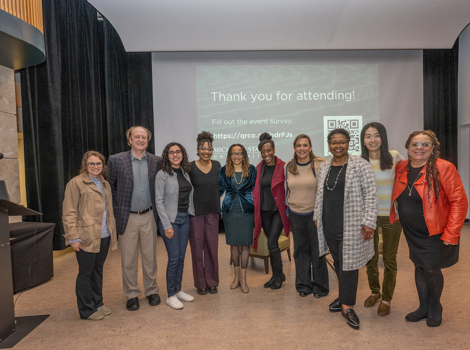 Attendees join Dorothy Roberts (center) on stage for a group photo