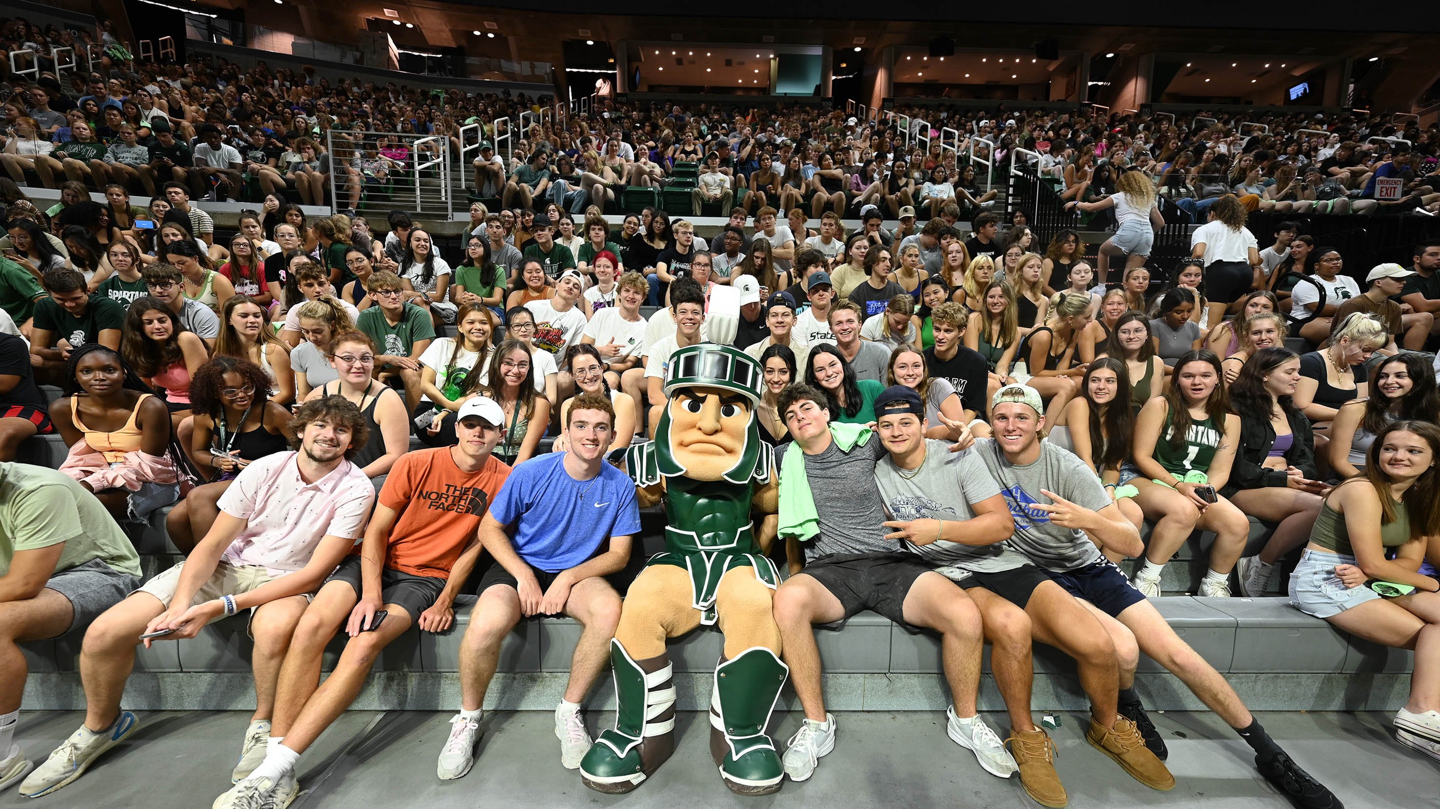 Undergrads sitting with Sparty at undergraduate convocation in Breslin Center