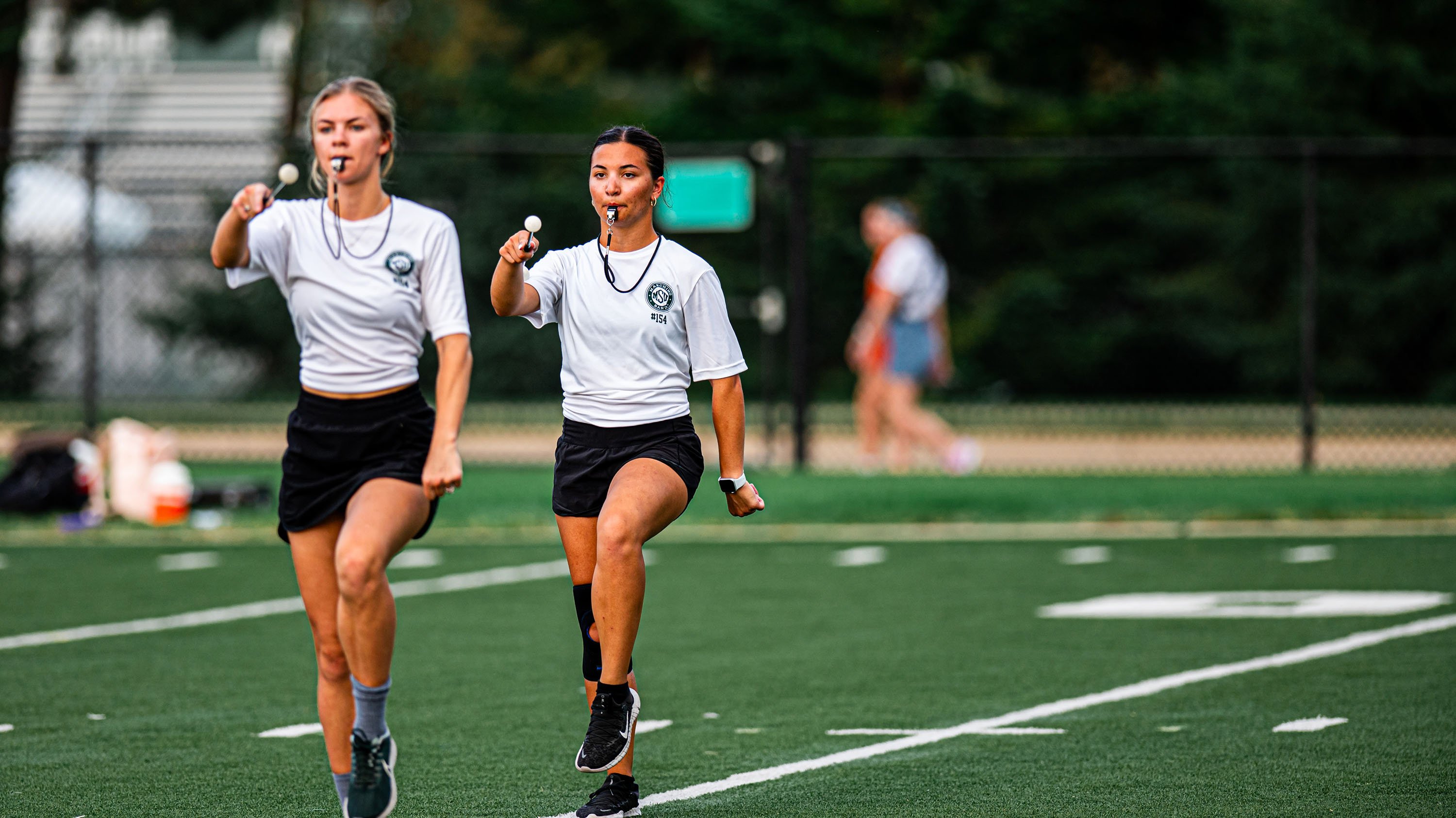 Samantha Barringer and Lacy Jewell marching on practice field