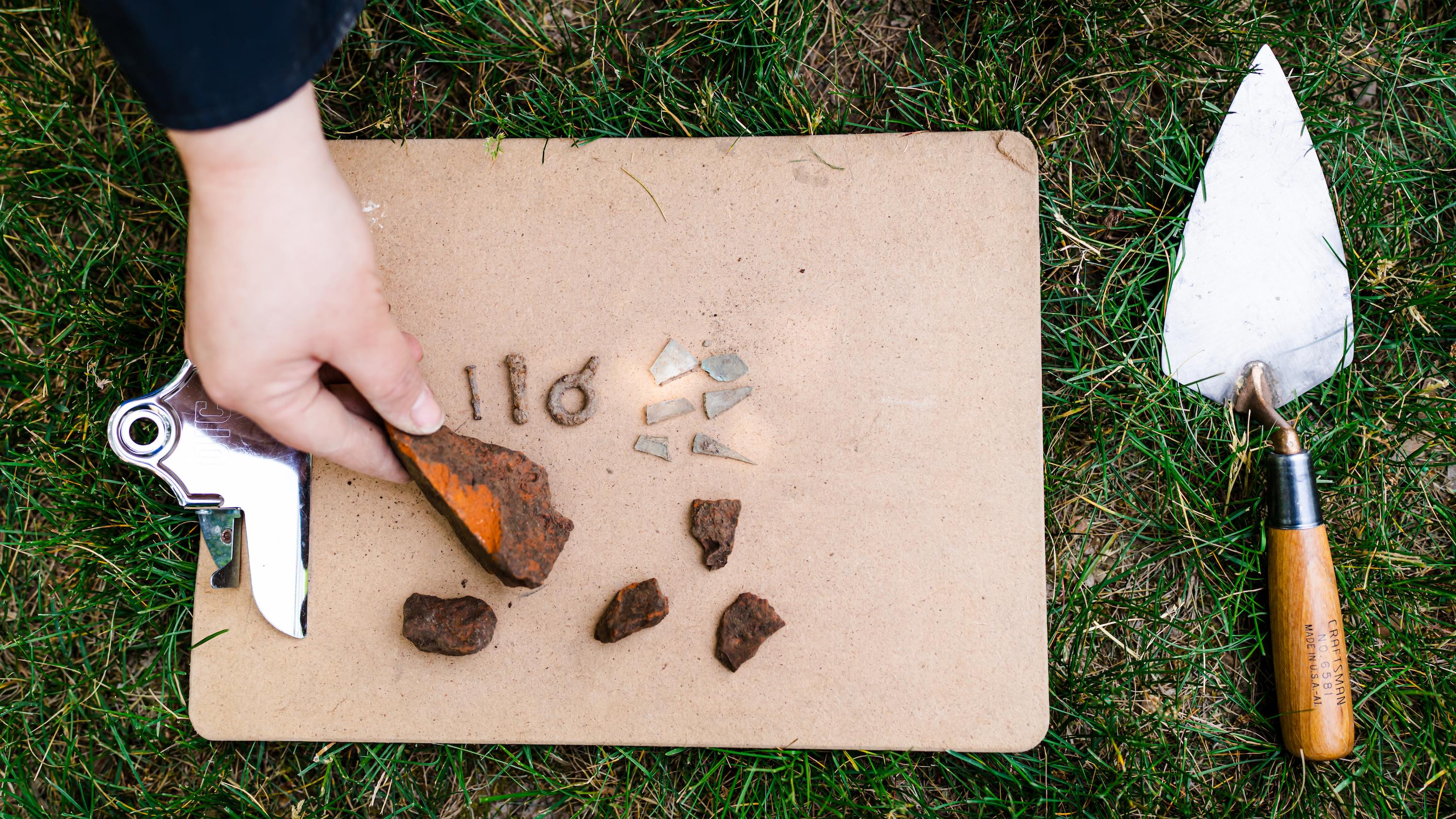 Objects found during archaeology dig on clipboard