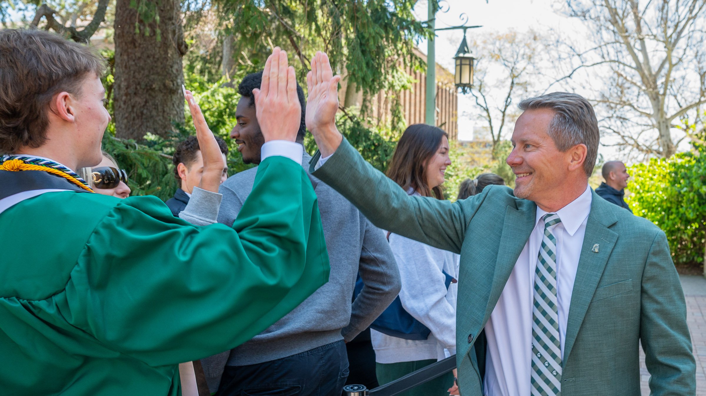 Kevin Guskiewicz high-fiving grads