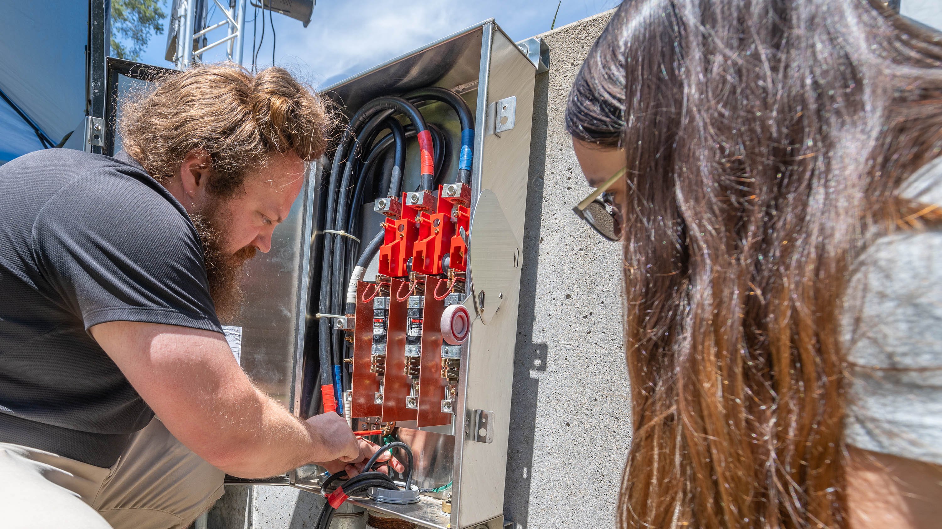 Lucas Nunn and Melina Rodriguez, install audio equipment for the 2024 Summer Circle Theater productions.