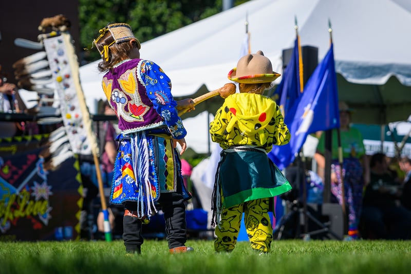 children at a powwow dance dressed in bright colors