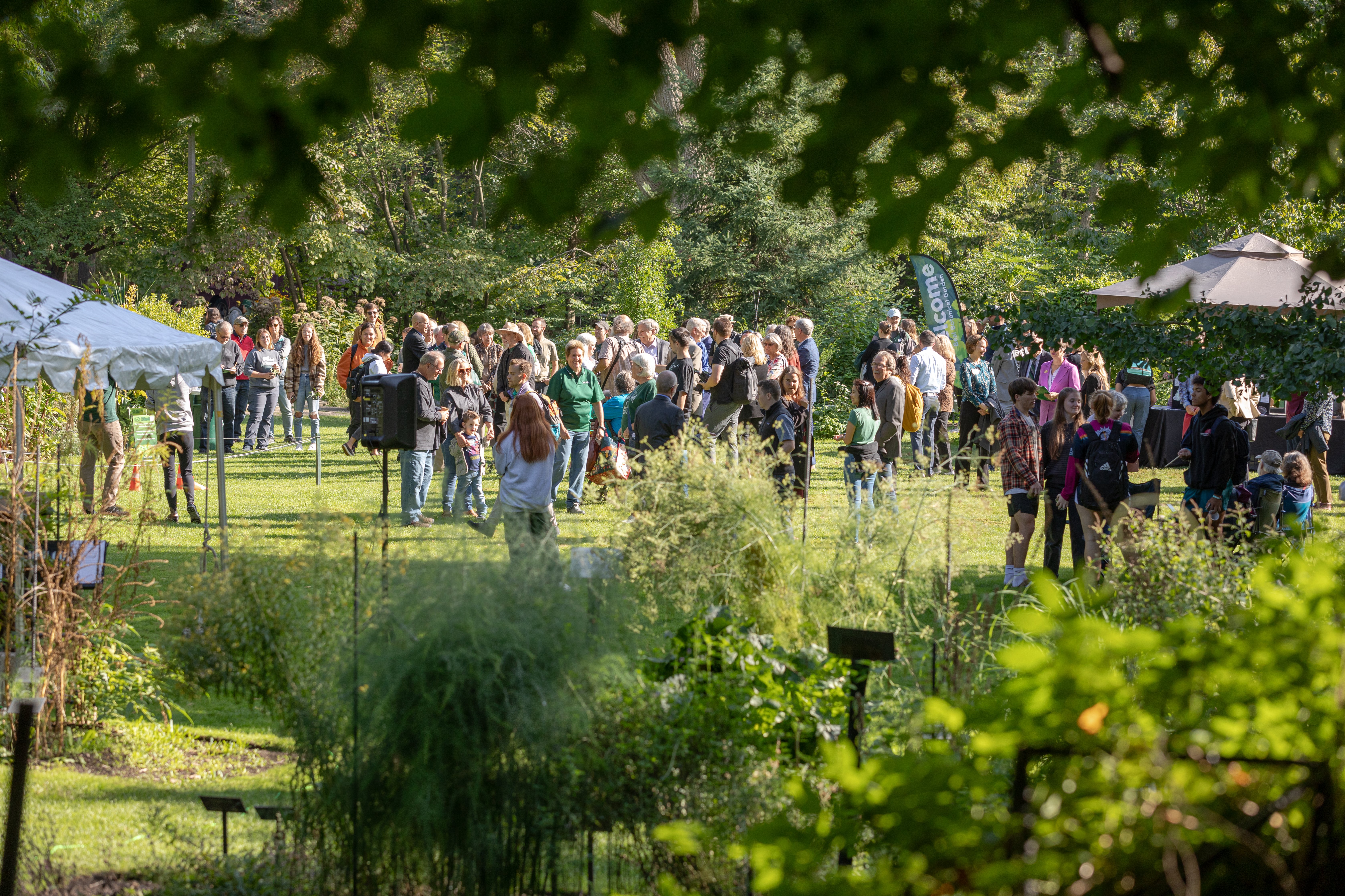 large group of people standing in a lawn space at a garden event