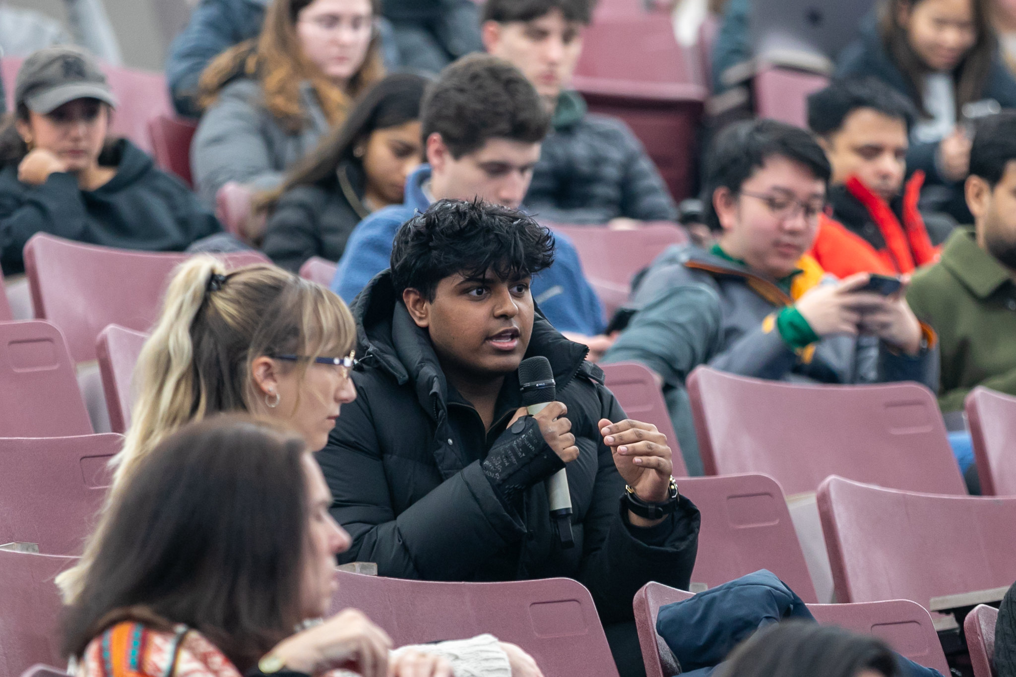 A Michigan State University student holds a microphone and asks a question during an Ethics Week 2025 lecture.