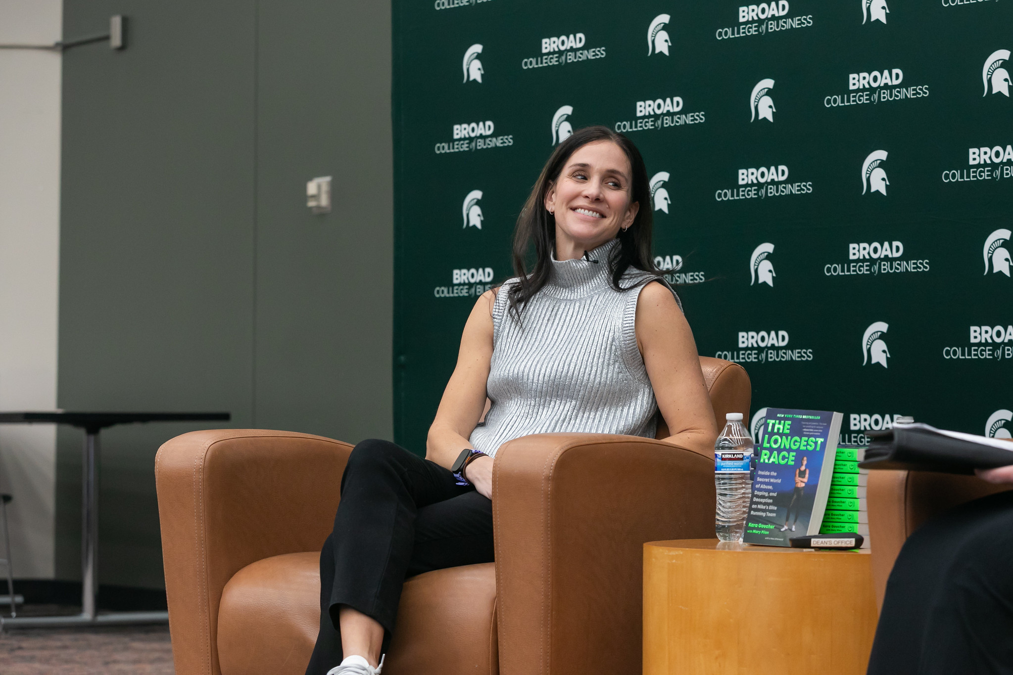 Kara Goucher sits in a chair with a Broad College of Business backdrop behind her during her Ethics Week 2025 talk.