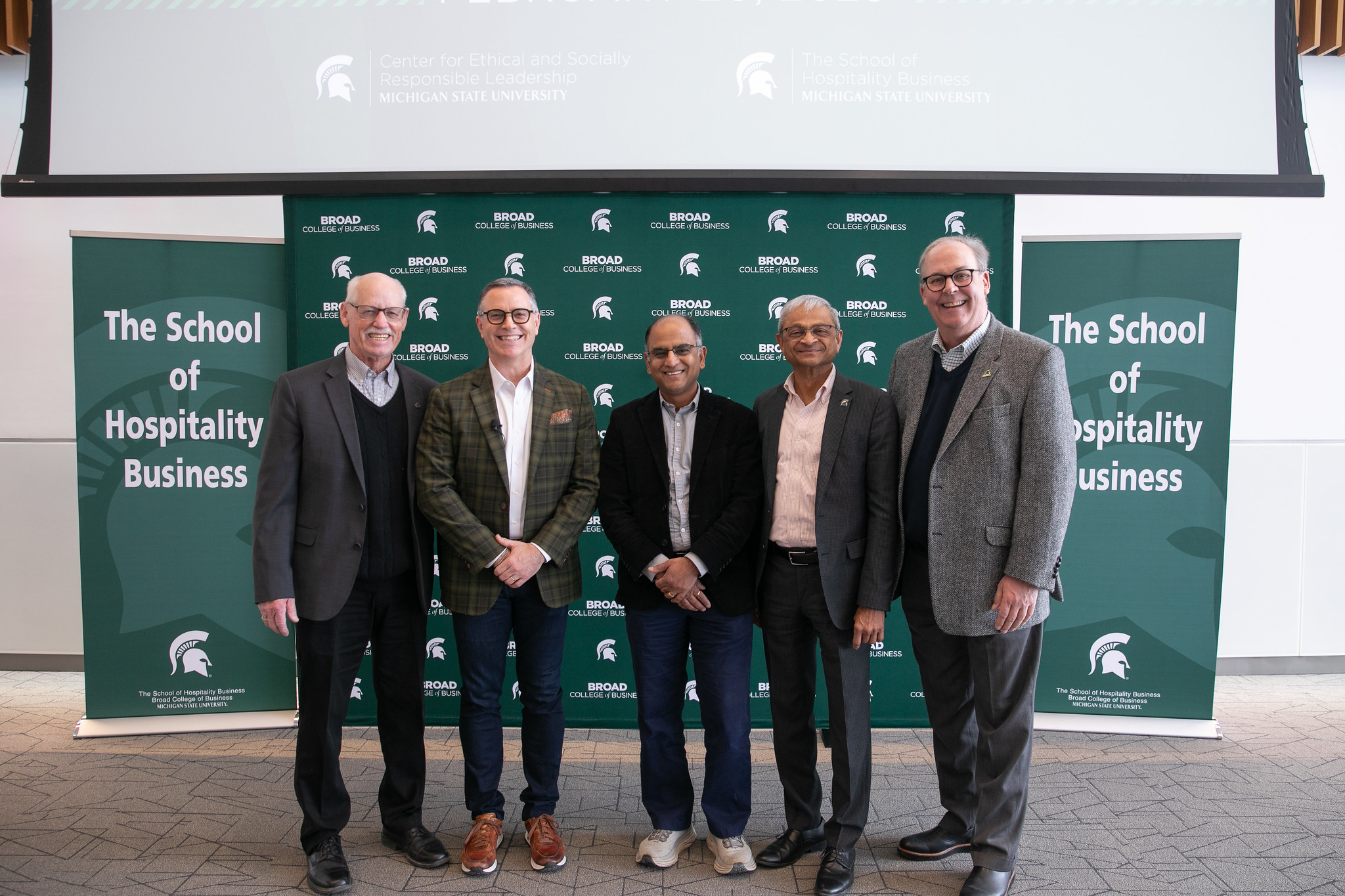 Michigan State University representatives pose for a group photo in front of a Broad College of Business backdrop.