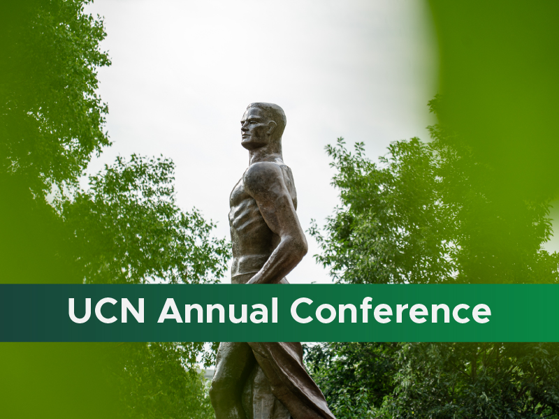 A photo of the Spartan statue, with a green stripe across the bottom of the graphic and white text reading "UCN Annual Conference"