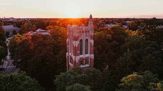 Beaumont Tower as viewed from a drone. The sun is rising on the horizon.