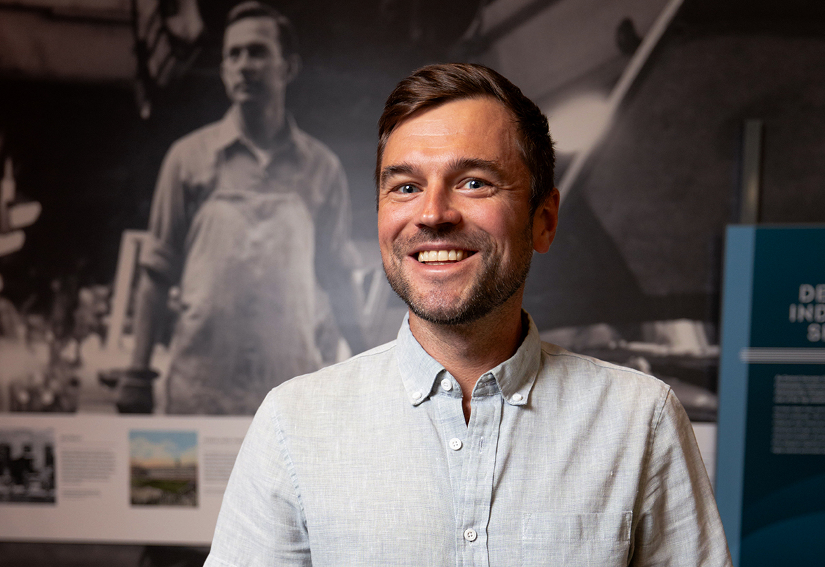  a smiling person standing in front of a wall with photos