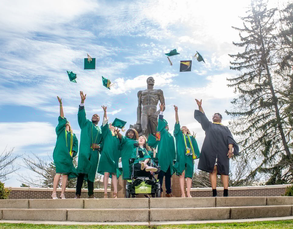Students celebrating graduation throwing caps in the air.