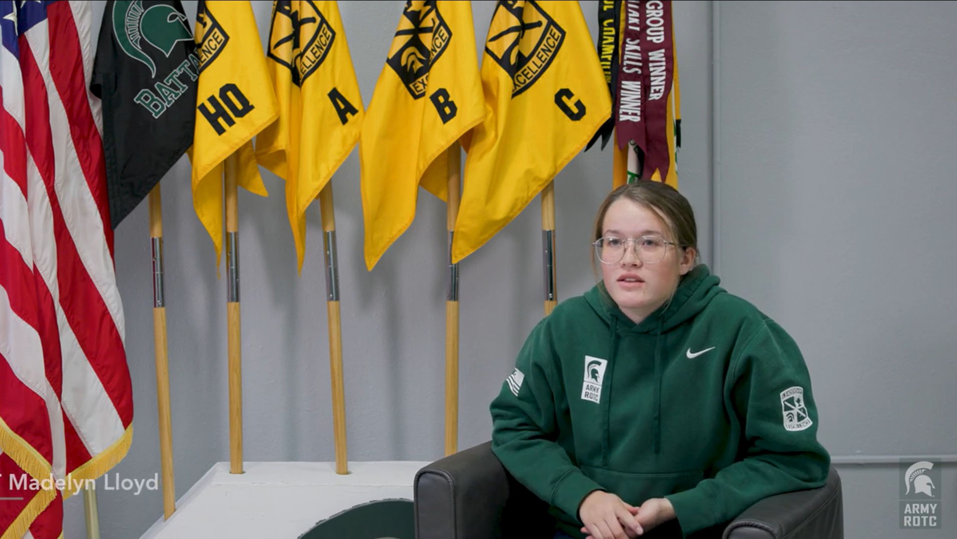 Madelyn Lloyd sitting in front of a row of flags