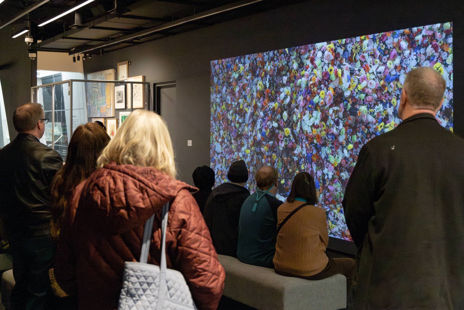 group of people looking at art on a wall