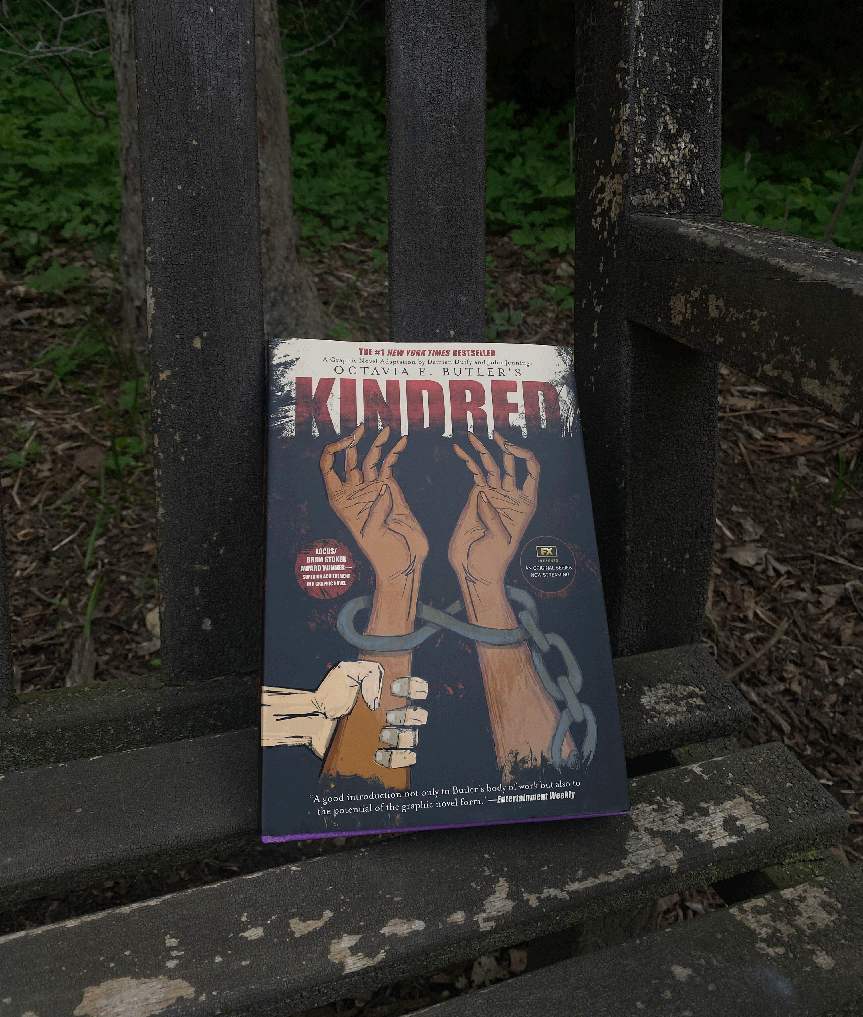 photo of Kindred by Octavia Butler sitting on a dark wooden bench