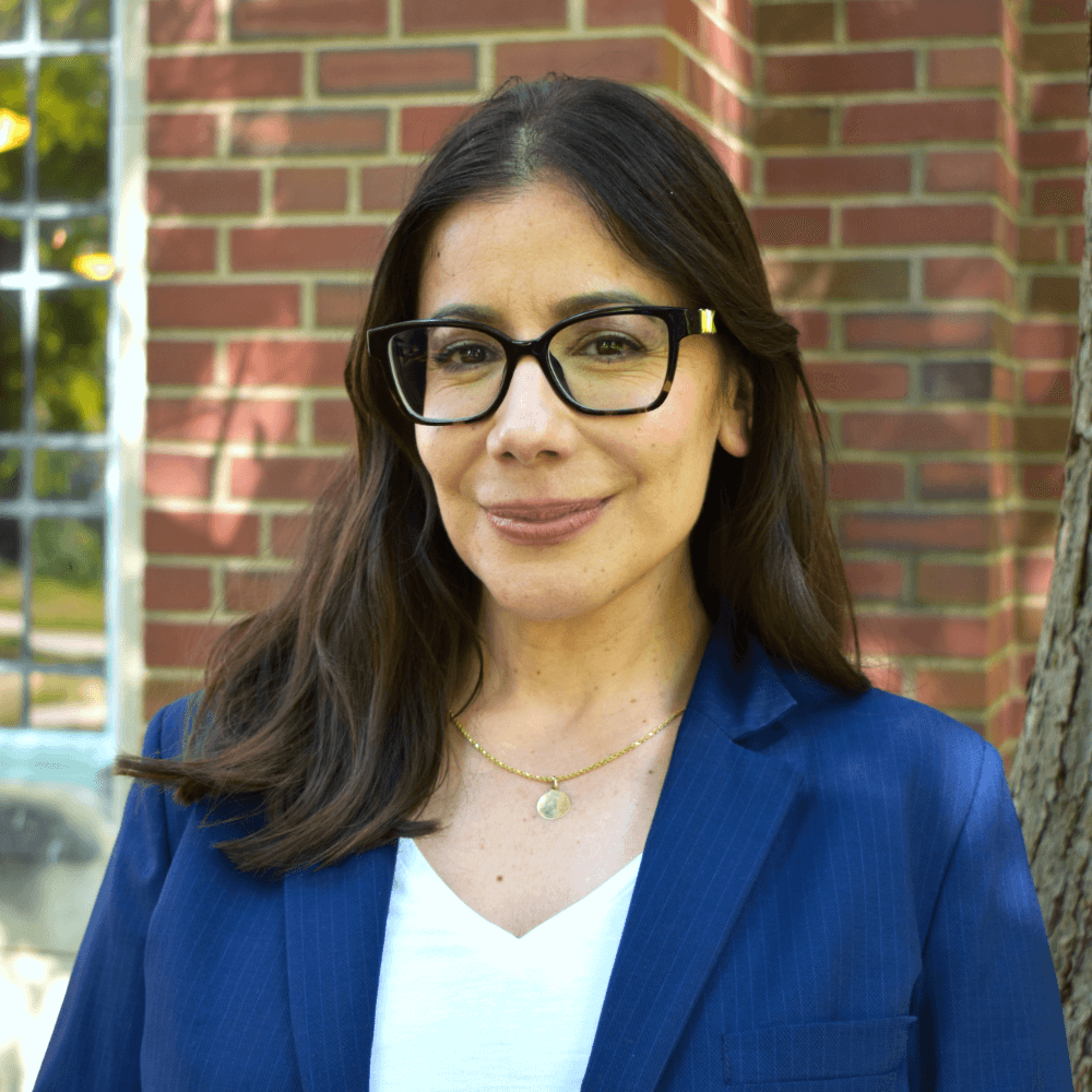 Headshot of Vivian Aranda-Hughes in front of a brick building.