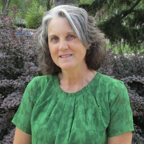 Headshot of Dr. Mary Finn in front of a nature background.