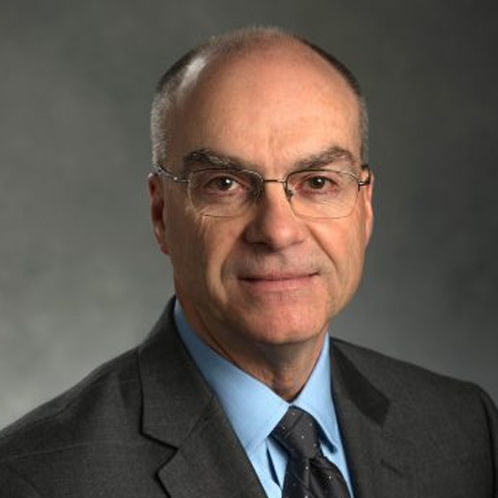 Headshot of Dr. Ed McGarrell in front of a professional background.