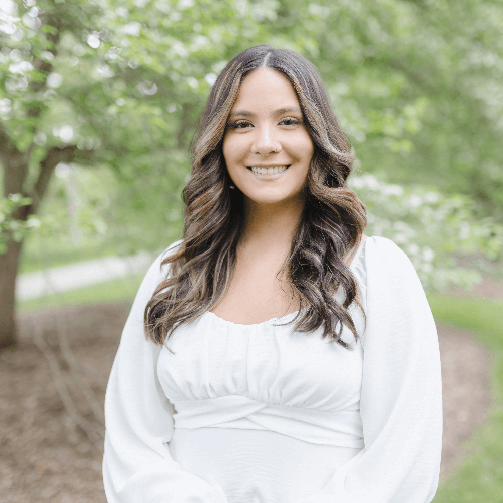 Headshot of Natalie Rivera in front of a treeline background