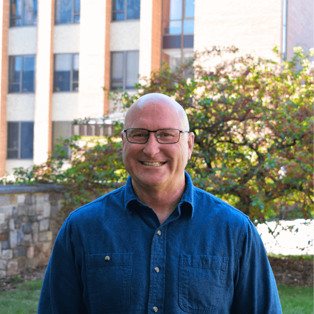 Headshot of Dr. jeff Rojek in front of Baker Hall on Michigan State University's campus.