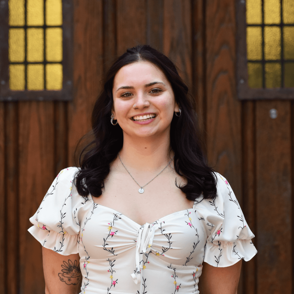Headshot of Izabela Weglarz standing in front of a wooden door background
