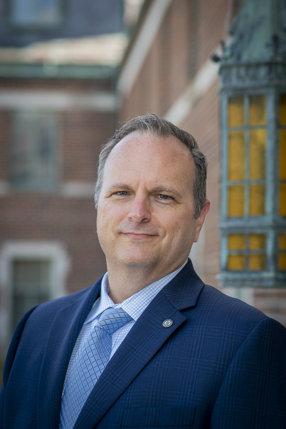 Headshot of Jeremy Wilson in front of a brick building on MSU's campus
