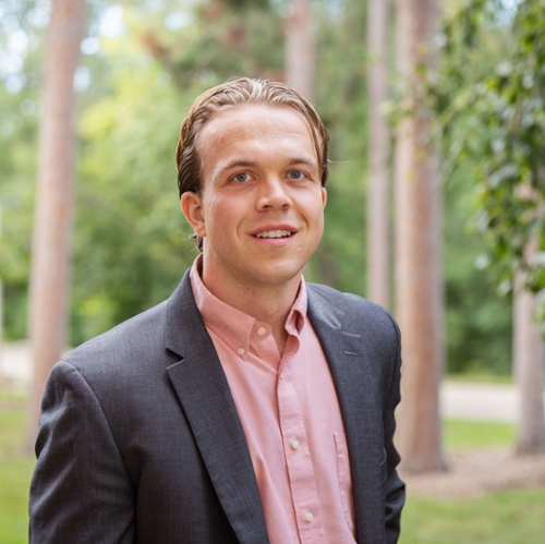 Headshot of Niel Filosa in front of a nature background.