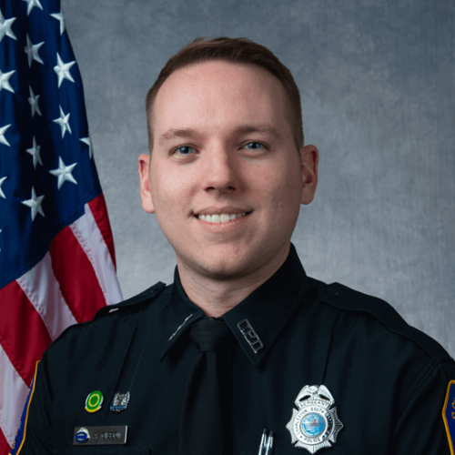 Headshot of Anthony Gibson in front of a professional background and an American Flag.